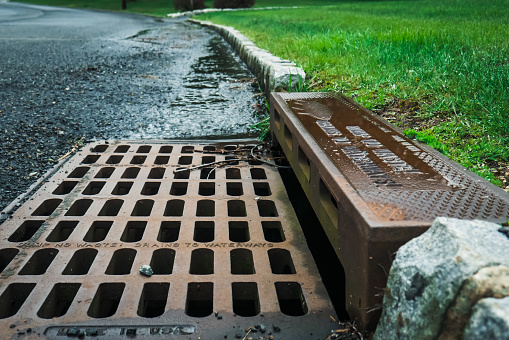 A storm drain on the side of a road